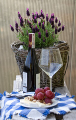 Relaksowy połudzień. Wino z winogron, sera i pistacji. Na tle wazon z lawęndą