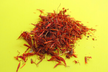 Naklejka premium sprinkled saffron on a yellow background, Indian spices , selective focus 