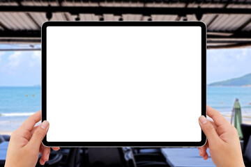 human two hands holding white tablet computer white screen mockup at beach restaurant