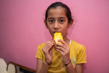 Happy little girl eating mango (lockdown activities)