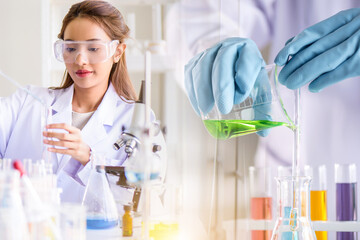 Beautiful Asian scientist woman lab technical service observe liquid sample with lab glassware and test tubes in chemical laboratory background, science laboratory research and development concept.