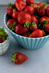 Bowl of strawberries on the kitchen table. Berries in a white plate. Strawberry crop. Food still life. Red summer berry. Vitamin breakfast.