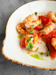 delicious prawns with grapefruit in a creamy sauce with herbs. top view