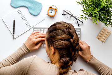 Tired girl sleeps on white office desk top view