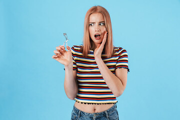 Image of beautiful shocked woman posing with eyelashes curler