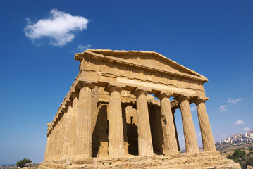 Fototapeta premium Temple Of Concordia And White Cloud In The Valley Of Temples In Agrigento, A Sicily Landmark Of Unesco Architecture