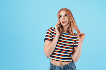Image of charming pleased woman talking on cellphone and smiling