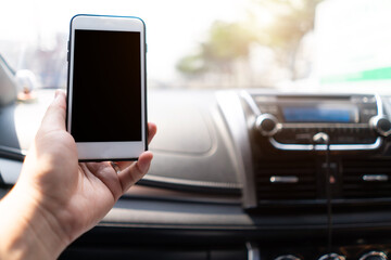 Hand holding mobile phone in car with Clipping path. man sitting in car holding phone.