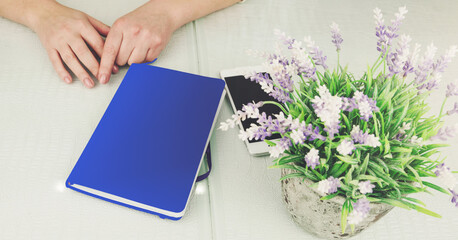 lady sits at table with lavender pot plant modern white smartphone purple notebook