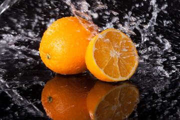 Orange in water splash on black background