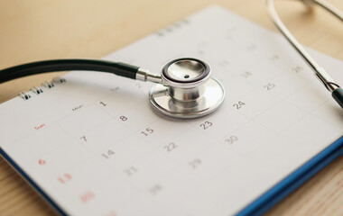 Stethoscope with calendar page date on wood table background doctor appointment medical concept