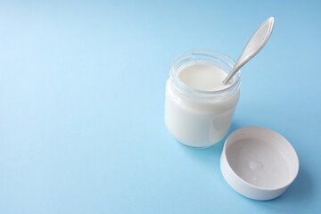 Homemade crockpot greek yogurt in glass jars on light blue background.