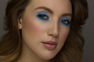 Obraz premium Close-up of the beauty of half a woman's face with creative fashionable make-up of sparkles. Black eyeliner and long eyelashes decorate hazel eyes and lips to match. Well-groomed skin after spa