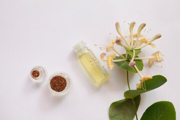 Lonicera caprifolium, honeysuckle flower essential oil (remedy, extract) jar isolated white. top view. Selective focus