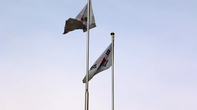 South Korea flags waving in Seoul, blue evening sky