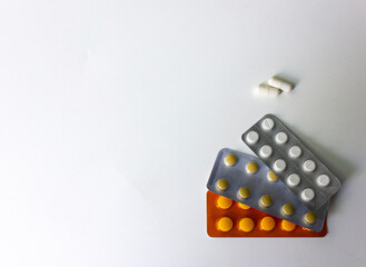 A lot of packs of white and orange pills are on the table