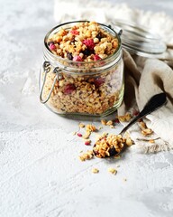 Homemade granola with berries and nuts in a bowl on a gray background