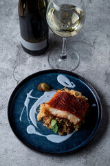 Fine dining restaurant: golden cod fillet with couscous and rice chips, garnished with unusual blue sauce