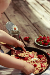 Pancake cereal with strawberries. Mini pancakes in a pan. Strawberry pastries