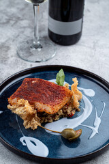 Close up of roasted cod with blueberry sauce on grey concrete background