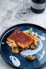 Close up of roasted cod with blueberry sauce on grey concrete background