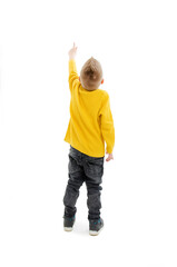 Back view of little boy points at wall. Rear view. Isolated on white background 
