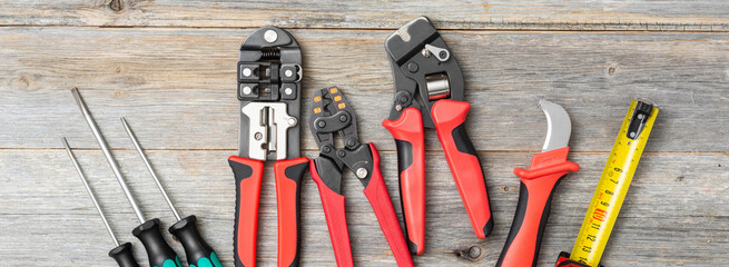 Tools of an electrician-fitter or Builder on a gray wooden table. Construction tools: screwdrivers,...