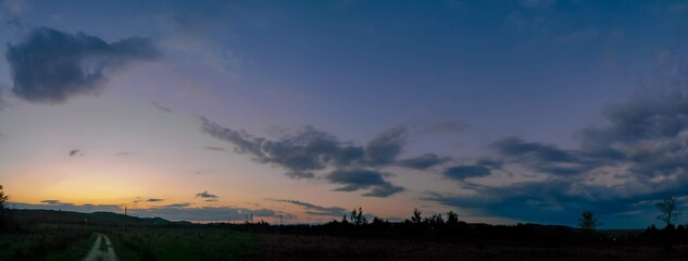 Fototapeta premium beautiful sunset with colorfully clouds close to the forest