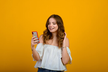 Excited woman with digital device. Studio shot of shocked girl holding smartphone, emotional