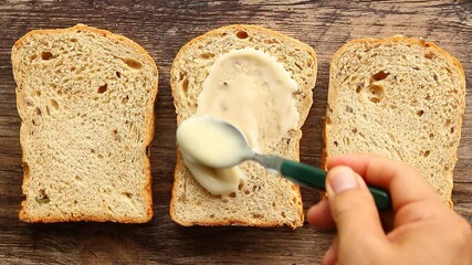 Spreading   salad  cream on bread , indoor  Chiangmai Thailand