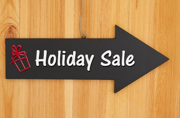 Holiday Sale type message on hanging arrow chalkboard sign with a red present