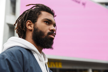 Handsome serious young man walking outdoors