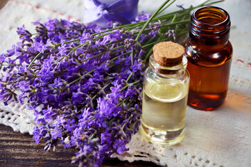 Obraz na płótnie Canvas A bottle of essential oil with fresh lavender twigs ,selective focus..