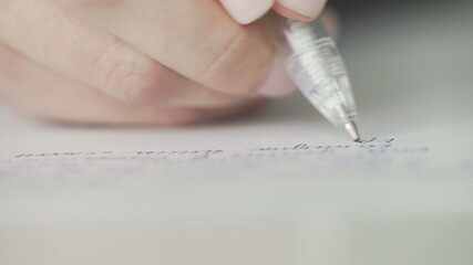 Macro of woman writing with pen.