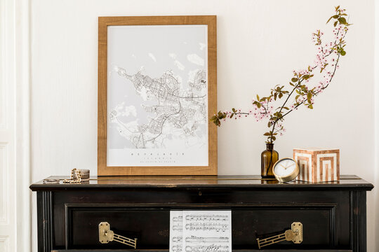 Stylish composition at living room interior with black piano, mock up poster map, dried flowers in vase, decoration and elegant presonal accessories in modern home decor.
