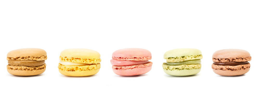 Diferentes macarons sabrosos sobre fondo blanco liso y aislado. Vista de frente y de cerca. Copy space. Formato panor&aacute;mico