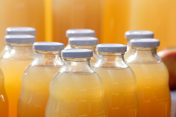 Glasflaschen mit orangen Fruchtsaft gefüllt