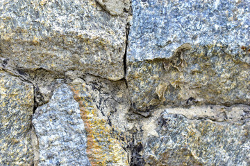 Gray blue old wall made of colored stones and cement