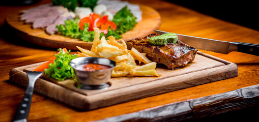 Beef steak with pepper sauce and Grilled vegetables on cutting board  dark wooden background