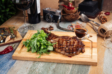 Juicy appetizing beef steak with sauce and greens