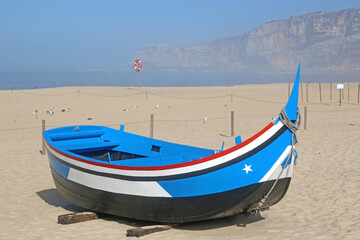 Fototapeta premium Traditional fishing boat on Nazare beach, Portugal