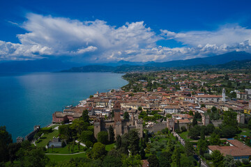 Fototapeta premium Lazise, Lake Garda, Italy. Aerial view of the historic part of Scaliger Castle of Lazise in the background cumulus clouds in the blue sky