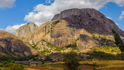 It's Landscape of three houses near the huge rock in Africa