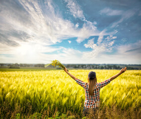 happy woman in a wheat field against sunset sky. freedom concept