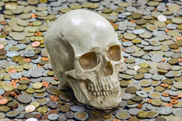 The skull is among a heap of different coins