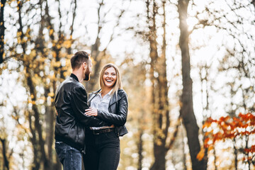 Beautiful young couple walking in the autumn park on a sunny day