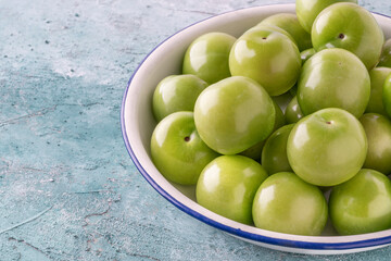 fresh and ripe green plums on a plate