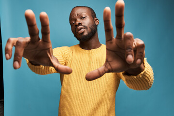 portrait photo of a dark-skinned handsome guy with a beard on a blue background in a yellow...