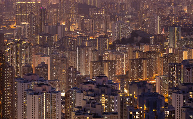 Crowded city with lights turning on and off at night. Hong Kong city apartment buildings at night. 