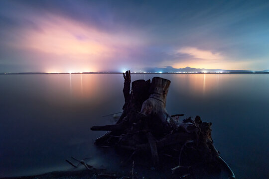Beautiful sunset landscape. Old stump in the lake on the with long exposure clouds. Sevan lake Armenia.